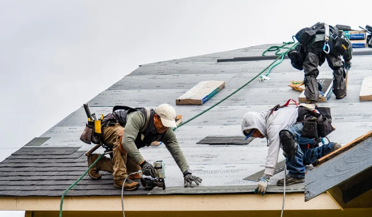 Roofer stripping old tiles from a scaffolded reroof